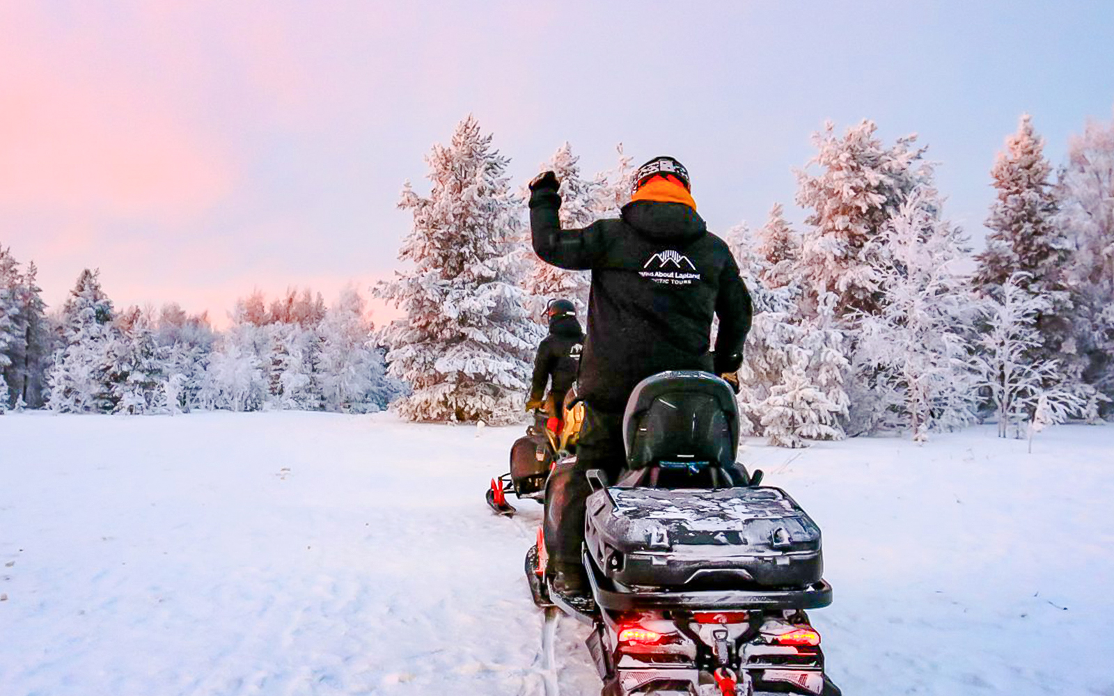 Snowmobilers riding through snowy forest during 1-Hour Snowmobile Safari Adventure from Rovaniemi.