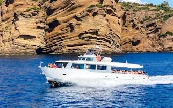 Boat cruising along rocky coastline during Monaco boat tour.