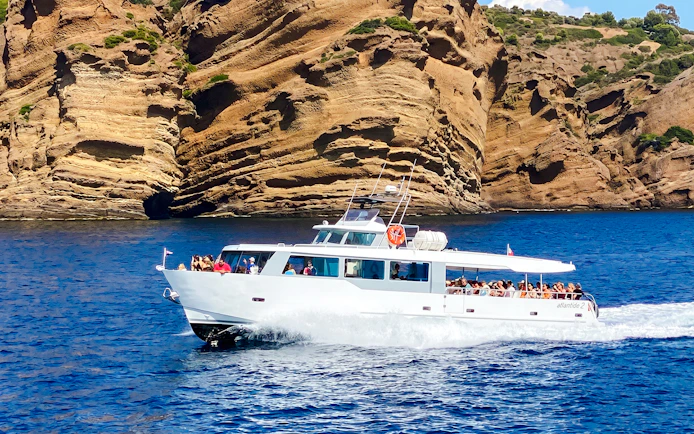 Boat cruising along rocky coastline during Monaco boat tour.