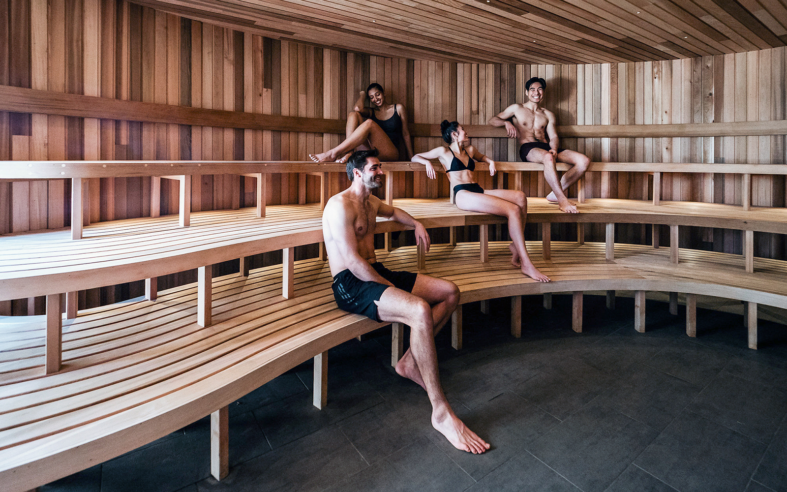 Visitors relaxing in a wooden sauna at Peninsula Hot Springs.