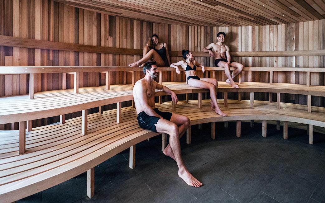 Visitors relaxing in a wooden sauna at Peninsula Hot Springs.