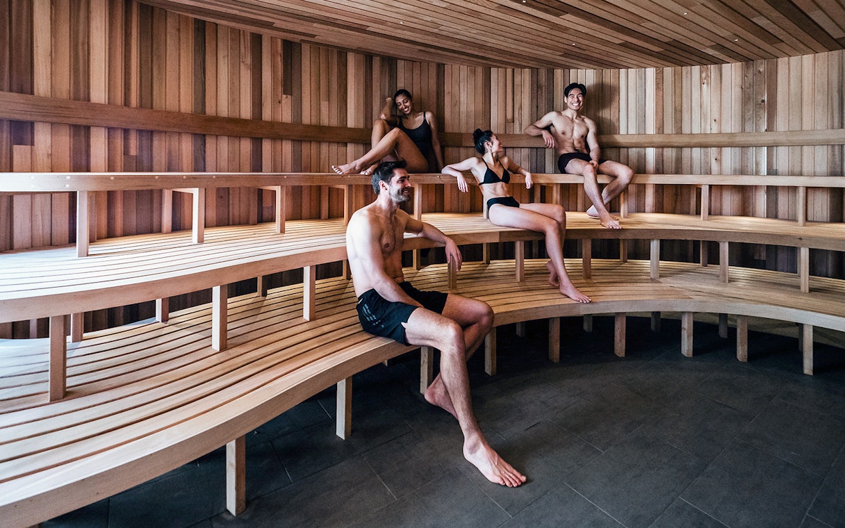 Visitors relaxing in a wooden sauna at Peninsula Hot Springs.