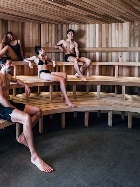 Visitors relaxing in a wooden sauna at Peninsula Hot Springs.
