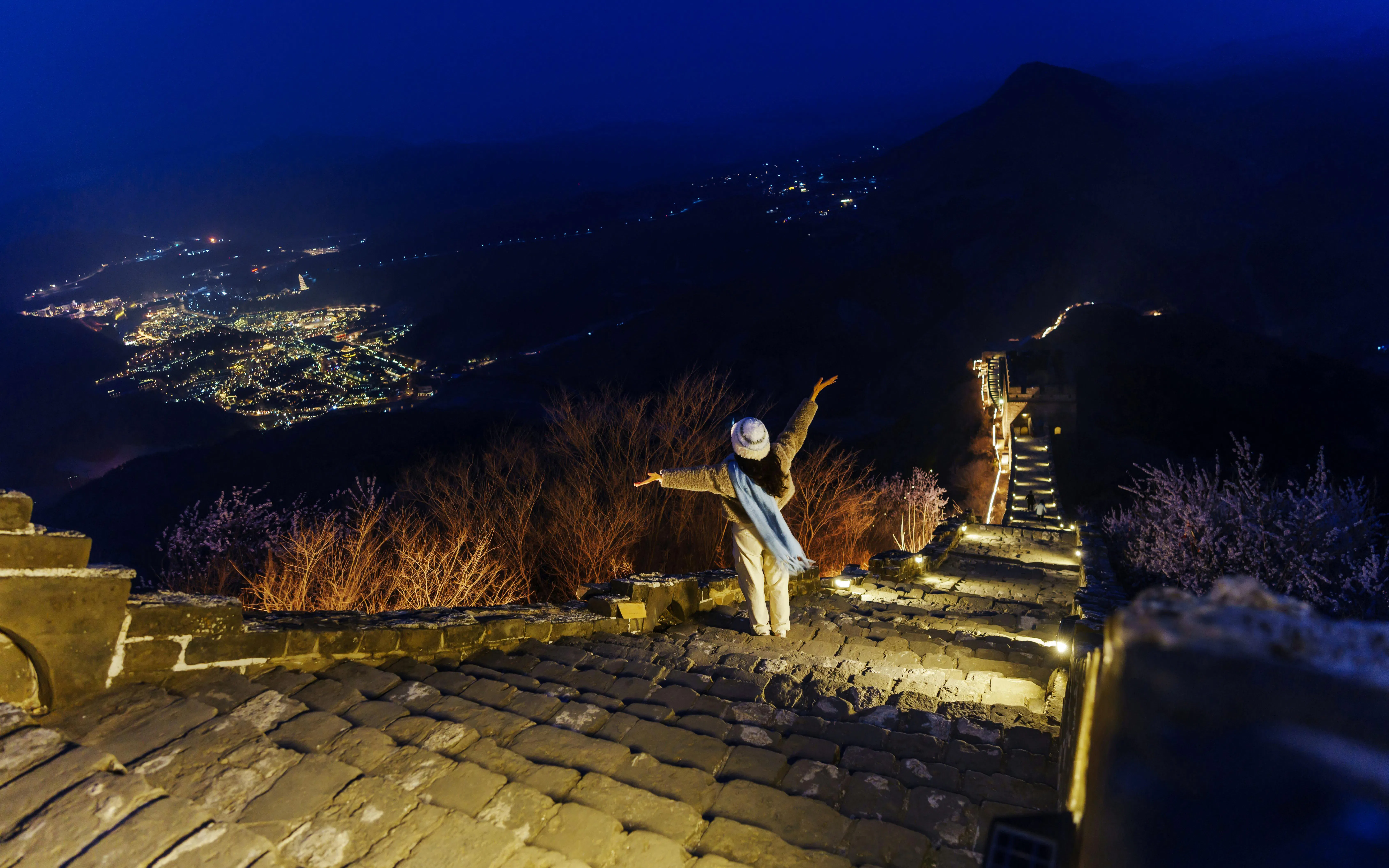 Traveler enjoying night view of illuminated Badaling Great Wall, Beijing.