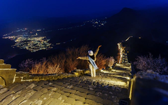 Traveler enjoying night view of illuminated Badaling Great Wall, Beijing.