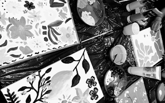 Paintings and art supplies on a table during a Barcelona sip and paint night.