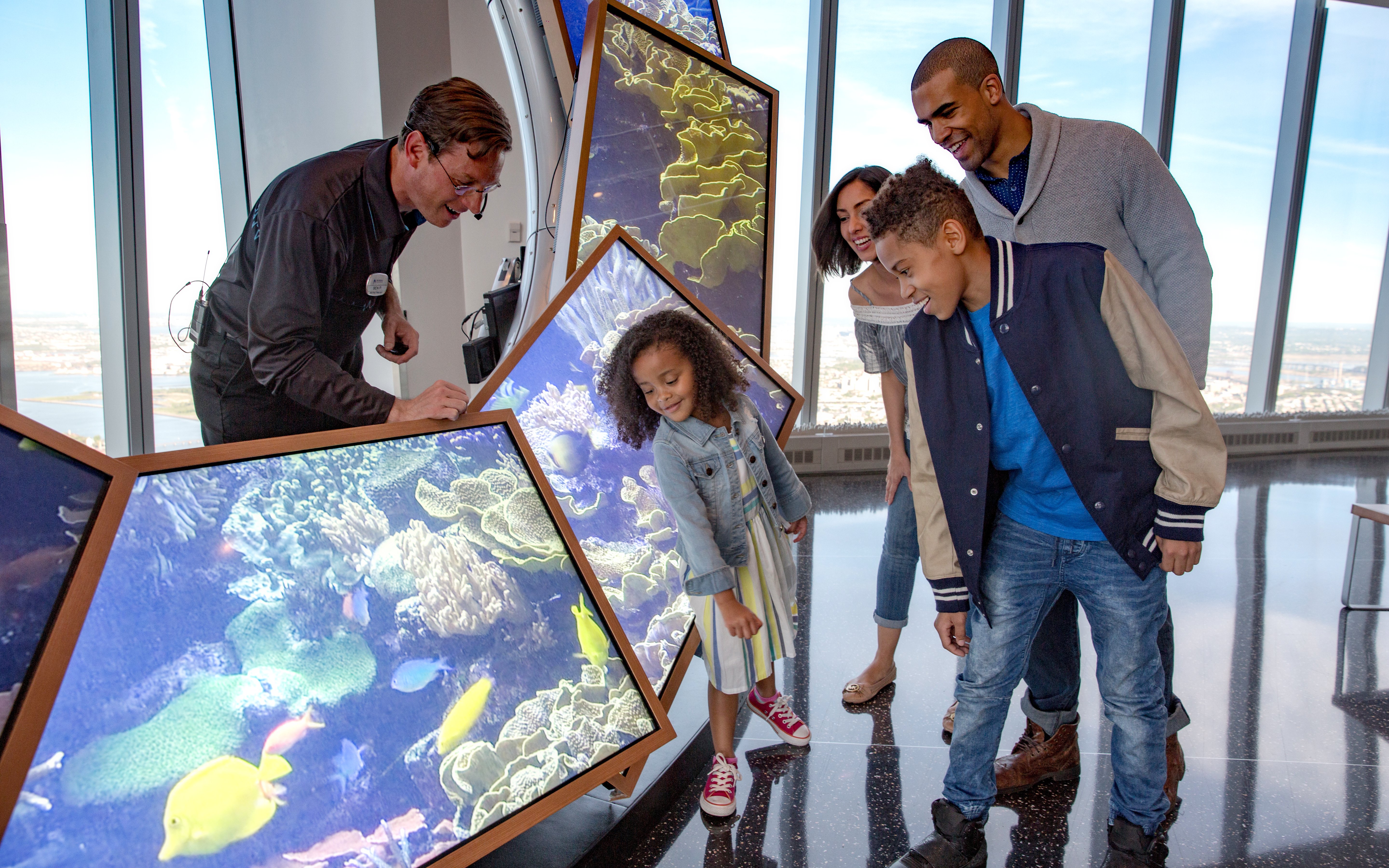 Family exploring interactive display at One World Observatory, New York.