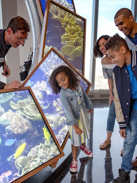 Family exploring interactive display at One World Observatory, New York.