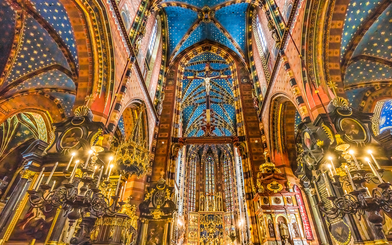 Interior of St. Mary's Basilica in Krakow, showcasing ornate ceiling and chandeliers.