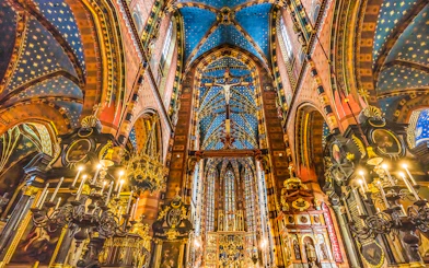Interior of St. Mary's Basilica in Krakow, showcasing ornate ceiling and chandeliers.