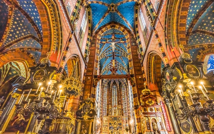 Interior of St. Mary's Basilica in Krakow, showcasing ornate ceiling and chandeliers.