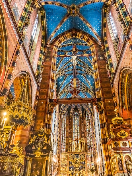 Interior of St. Mary's Basilica in Krakow, showcasing ornate ceiling and chandeliers.