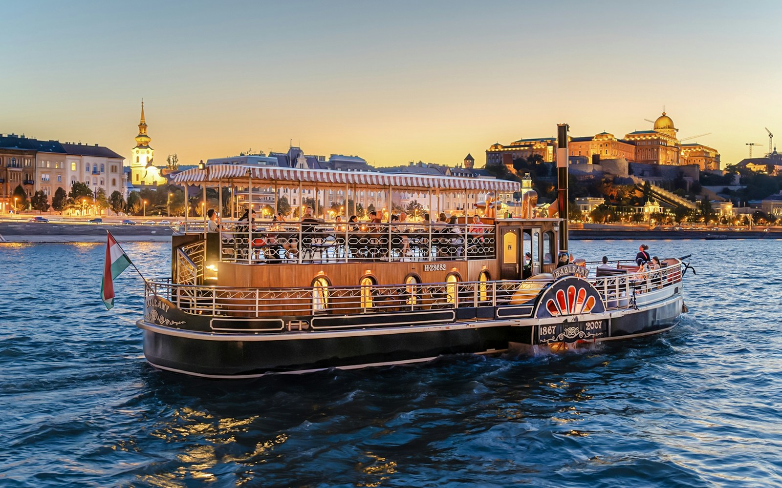 Budapest Danube River nighttime cruise with illuminated cityscape and historic buildings.