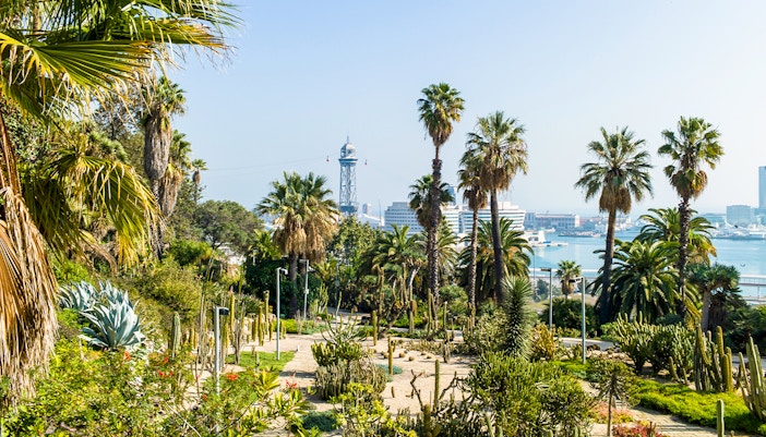 Joan Brossa Gardens pathway with sculptures and lush greenery in Barcelona, Spain.