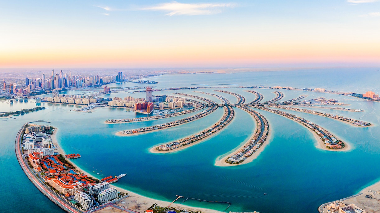 Aerial view of The Palm Jumeirah Island, Dubai with city skyline in the background.