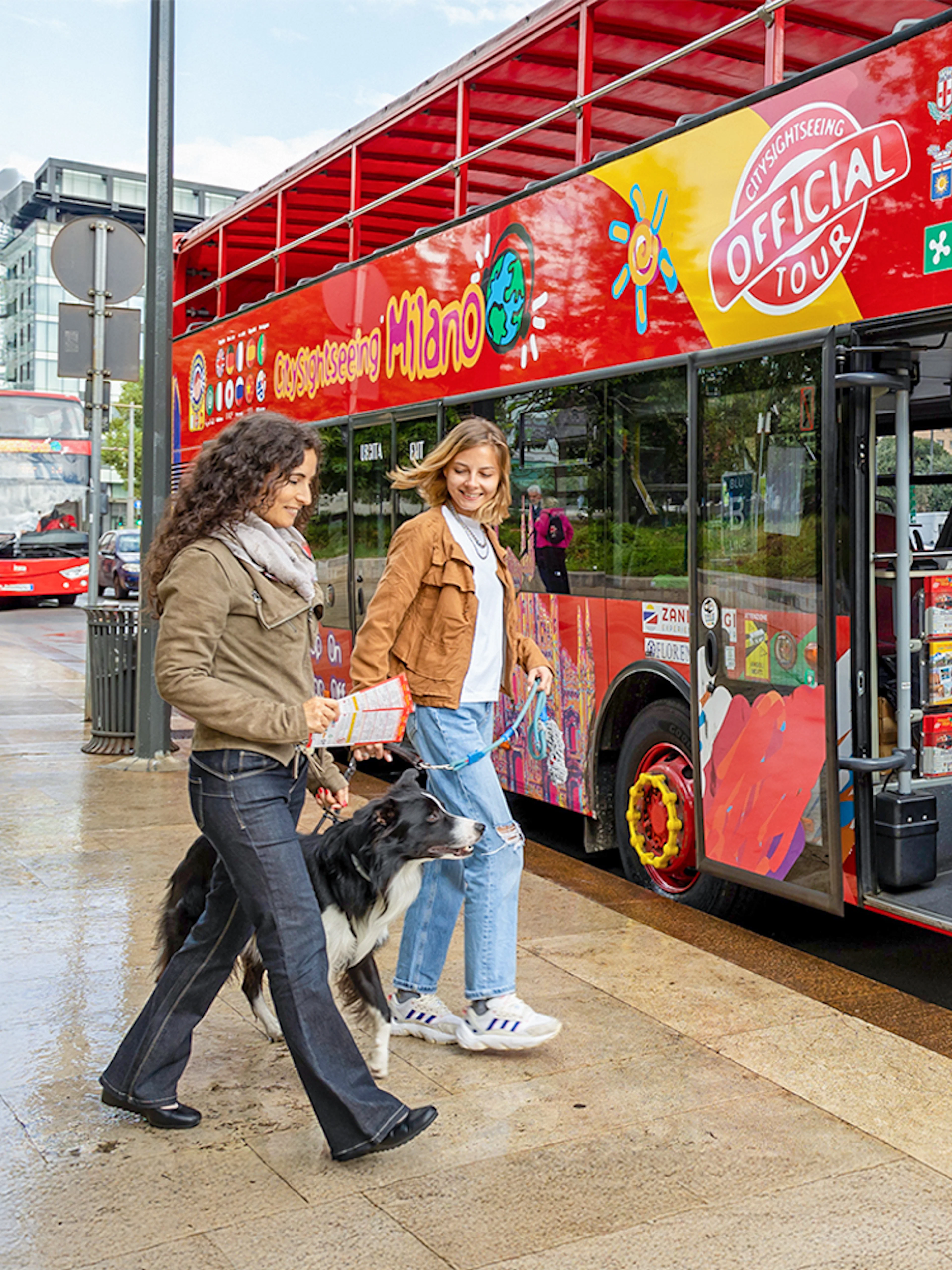 Friends boarding City Sightseeing Milan Hop On Hop Off Bus with a dog on leash.