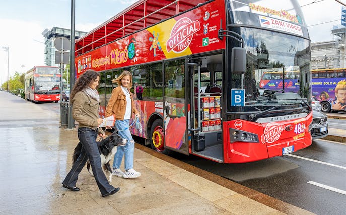 Friends boarding City Sightseeing Milan Hop On Hop Off Bus with a dog on leash.