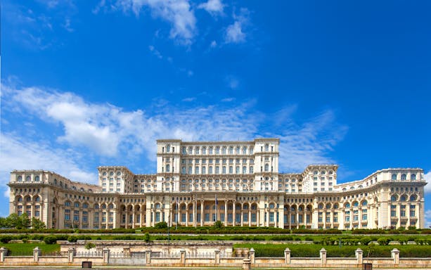 Palace of the Parliament in Bucharest, Romania, with clear blue sky.