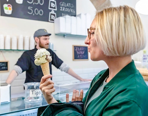 Woman enjoying gelato in a Rome gelateria during a food tour.