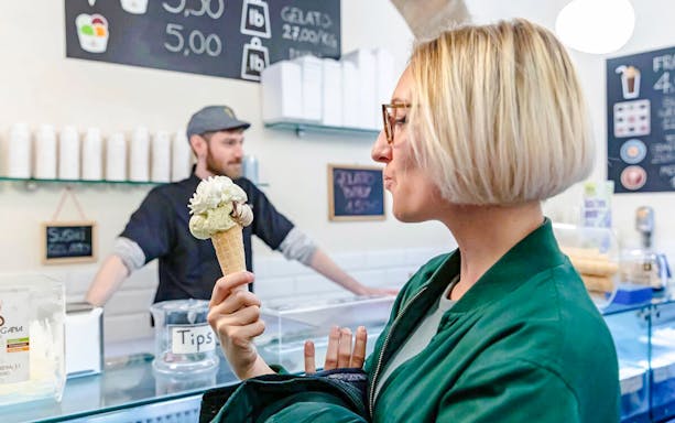 Woman enjoying gelato in a Rome gelateria during a food tour.