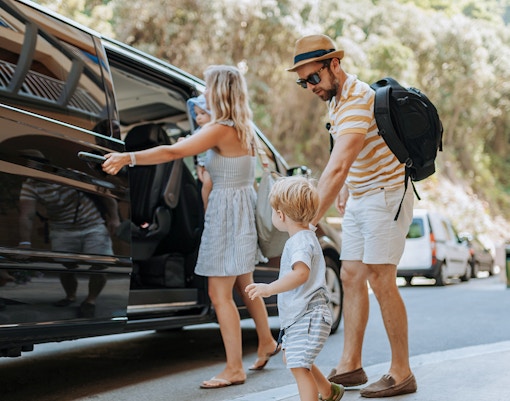 Tourists boarding an AC car for Lake Bled, Postojna Cave, and Predjama Castle tour from Ljubljana.