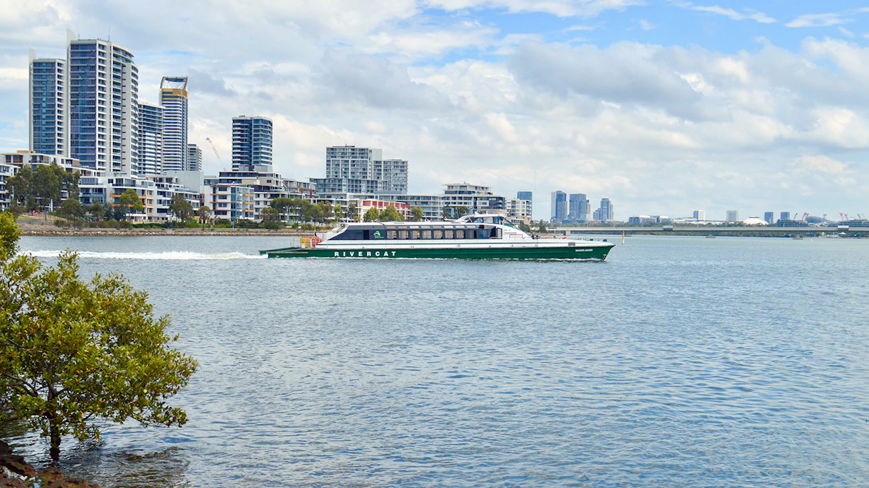 Ferry cruising along Parramatta River with Sydney skyline in the background.
