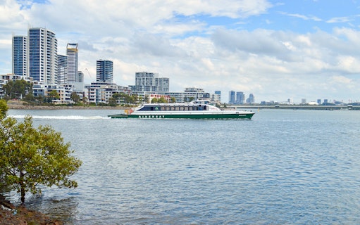 Ferry cruising along Parramatta River with city skyline in the background.