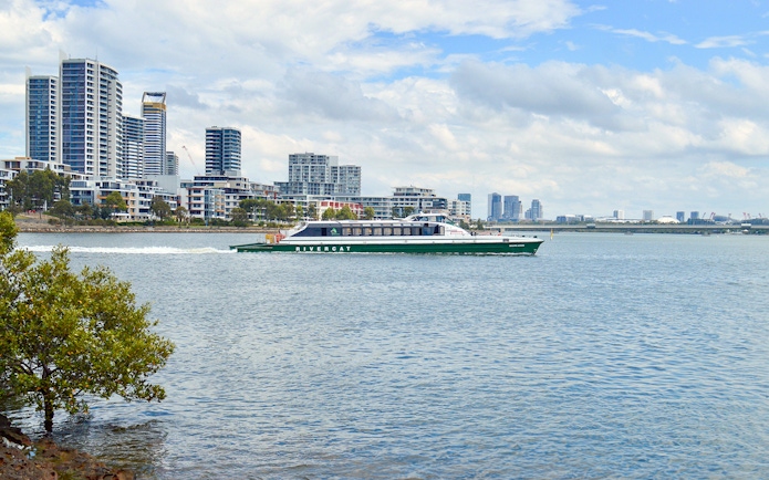 Ferry cruising along Parramatta River with city skyline in the background.
