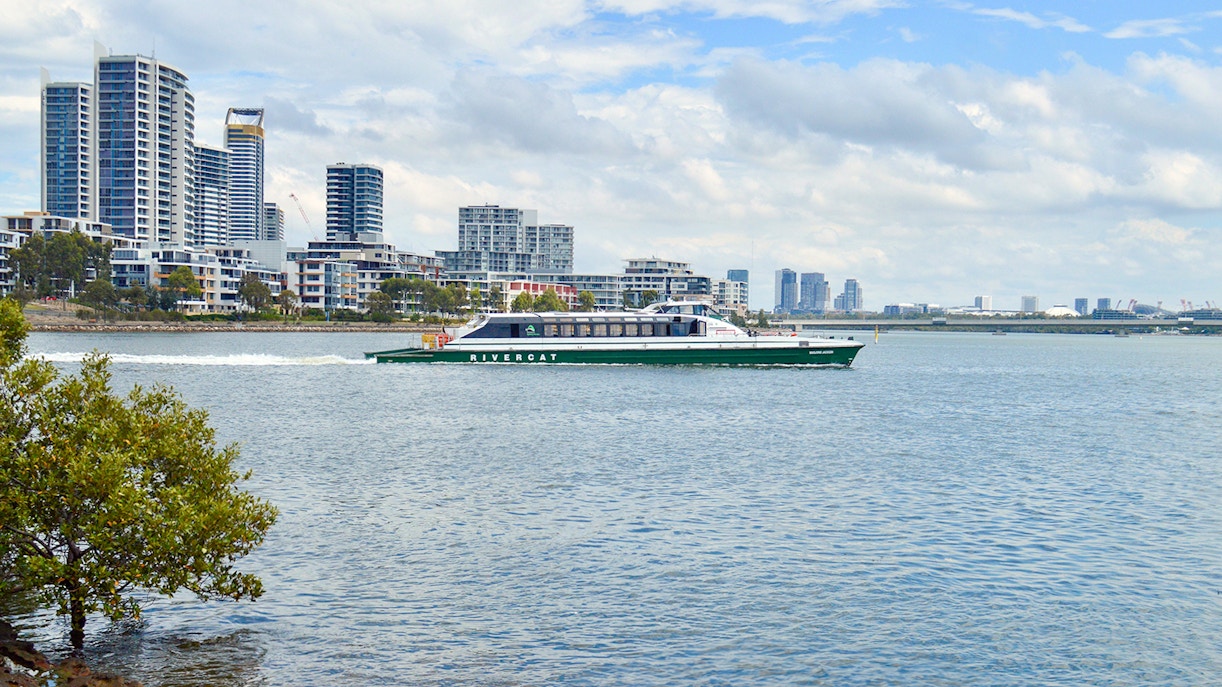 Ferry cruising along Parramatta River with Sydney skyline in the background.