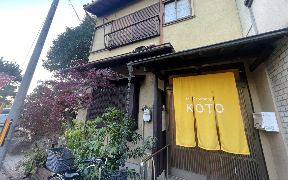 Entrance to Koto tea ceremony venue with yellow curtain in Japan.
