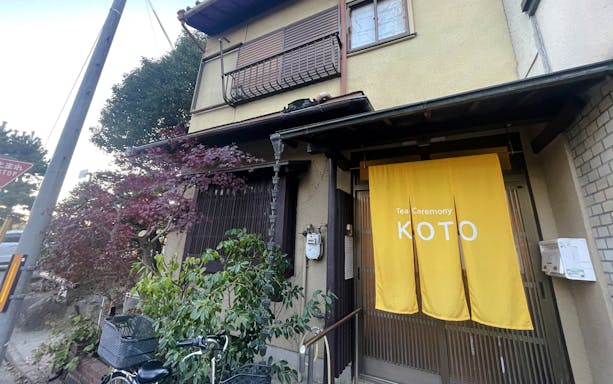 Entrance to Koto tea ceremony venue with yellow curtain in Japan.