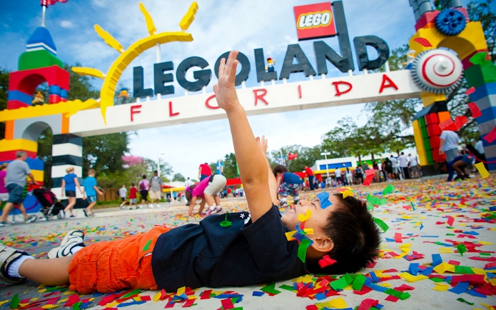 Child playing with confetti at LEGOLAND Florida entrance, Orlando Explorer City Pass.
