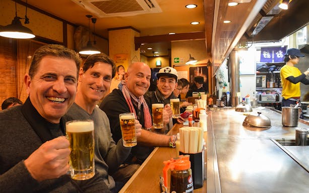 Group enjoying drinks at a local izakaya during the Best of Shibuya Food Tour.