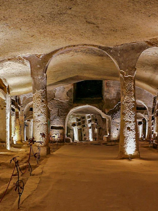 Catacombs of San Gennaro in Naples with illuminated arches on a guided tour.