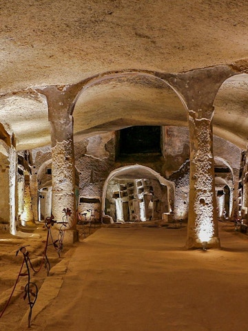 Catacombs of San Gennaro in Naples with illuminated arches on a guided tour.