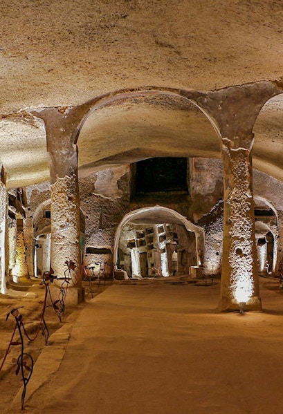 Catacombs of San Gennaro in Naples with illuminated arches on a guided tour.