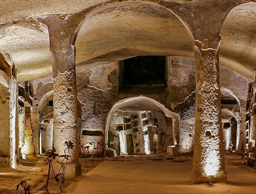 Catacombs of San Gennaro in Naples with illuminated arches on a guided tour.