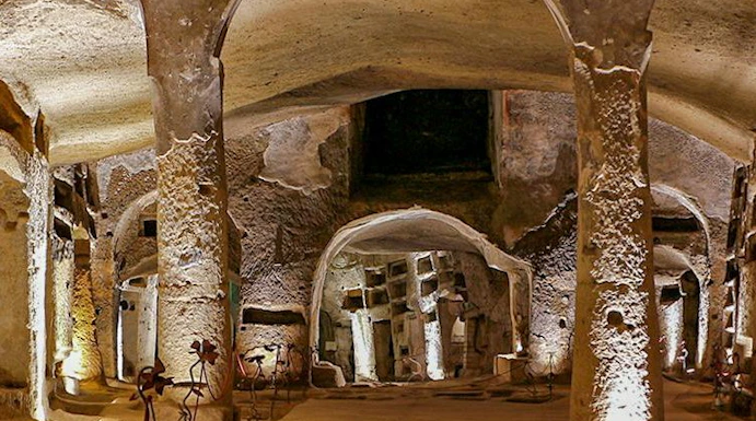 Catacombs of San Gennaro in Naples with illuminated arches on a guided tour.