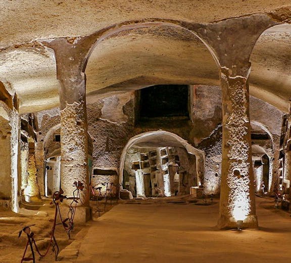 Catacombs of San Gennaro in Naples with illuminated arches on a guided tour.