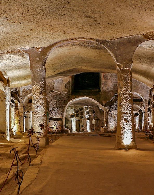 Catacombs of San Gennaro in Naples with illuminated arches on a guided tour.
