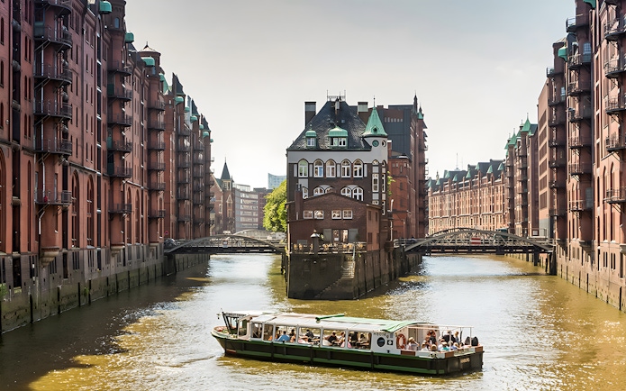 Boat tour through Hamburg's Speicherstadt with historic brick warehouses.