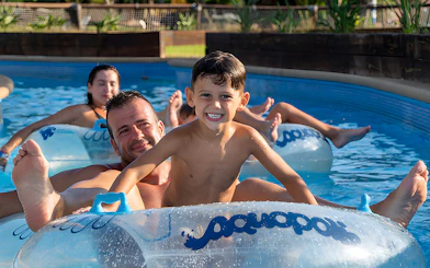Family floating on inflatable tubes at Aquopolis Torrevieja water park.