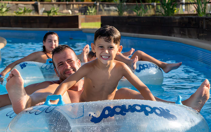 Family floating on inflatable tubes at Aquopolis Torrevieja water park.