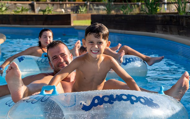 Family floating on inflatable tubes at Aquopolis Torrevieja water park.