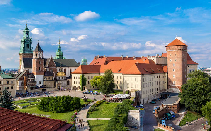 Wawel Castle and Cathedral in Krakow, Poland, with tourists exploring the grounds.