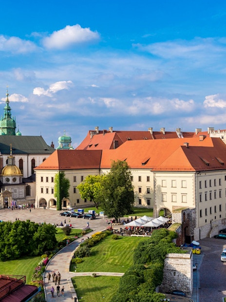 Wawel Castle and Cathedral in Krakow, Poland, with tourists exploring the grounds.