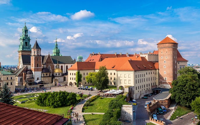 Wawel Castle and Cathedral in Krakow, Poland, with tourists exploring the grounds.