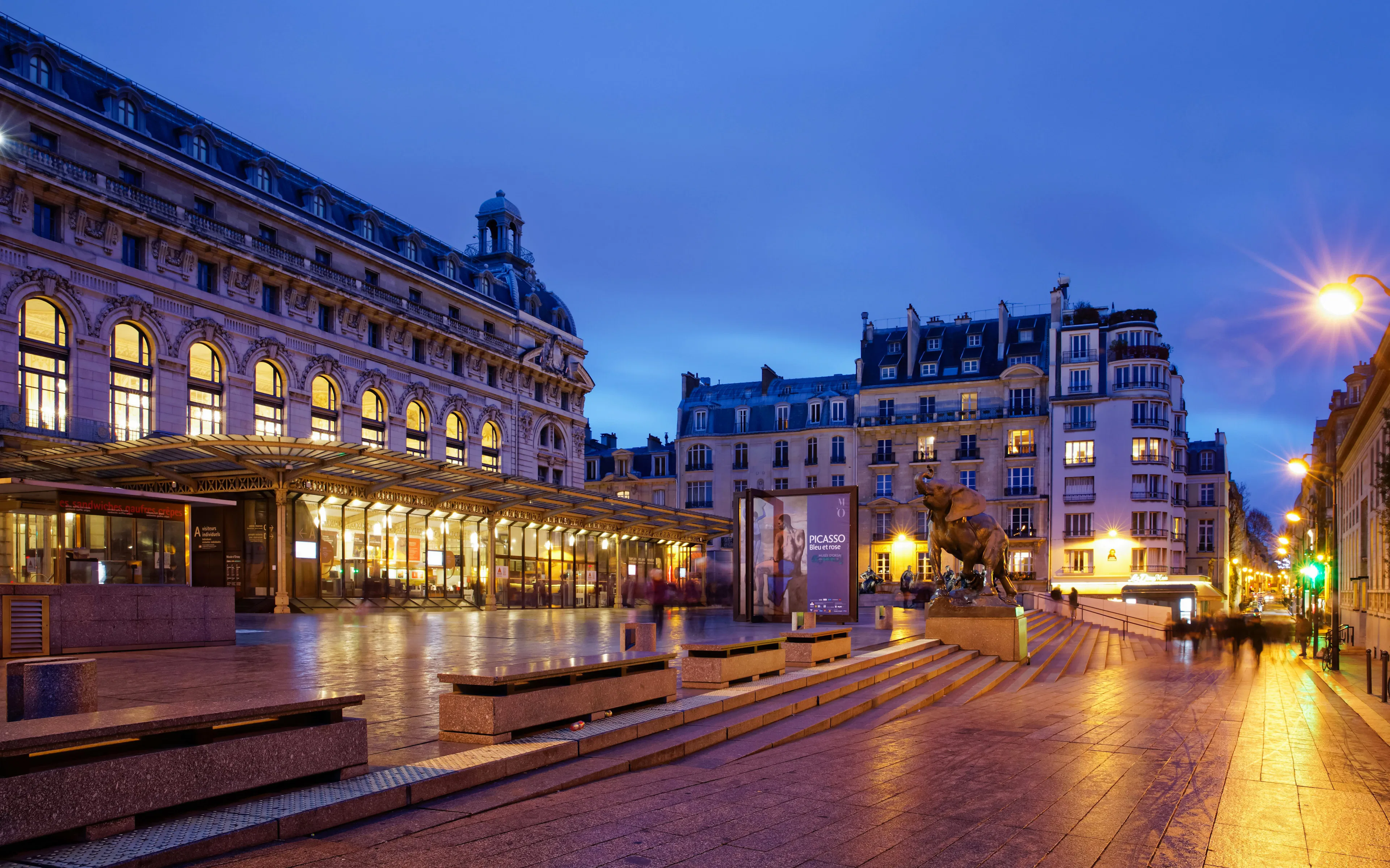 Orsay Museum illuminated at night in Paris, with surrounding architecture.