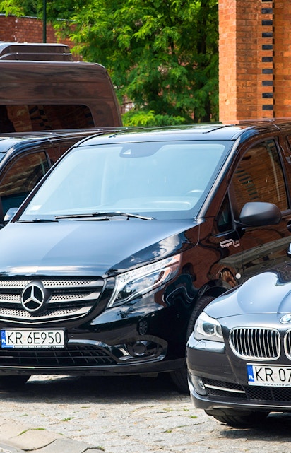 Krakow airport transfer vehicles parked near brick building.
