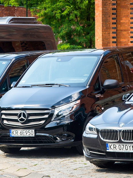 Krakow airport transfer vehicles parked near brick building.